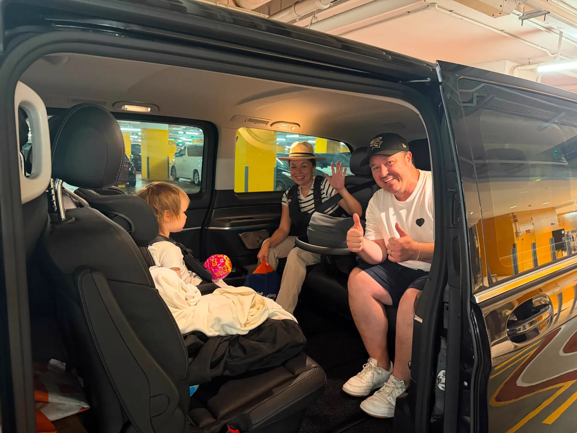 A family seated in a Mercedes V-Class with a fitted child seat, ready to depart